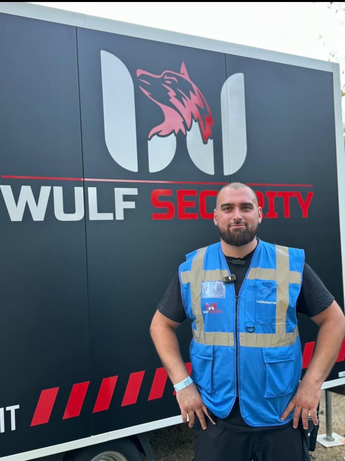 Medewerker van Wulf Security in blauw hesje voor de commando-unit, een aanhanger met het logo van het bedrijf